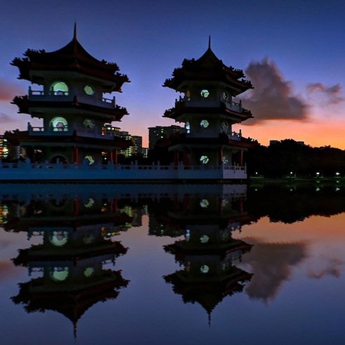 Buildings at the Chinese Garden reflected in the water as the sun sets